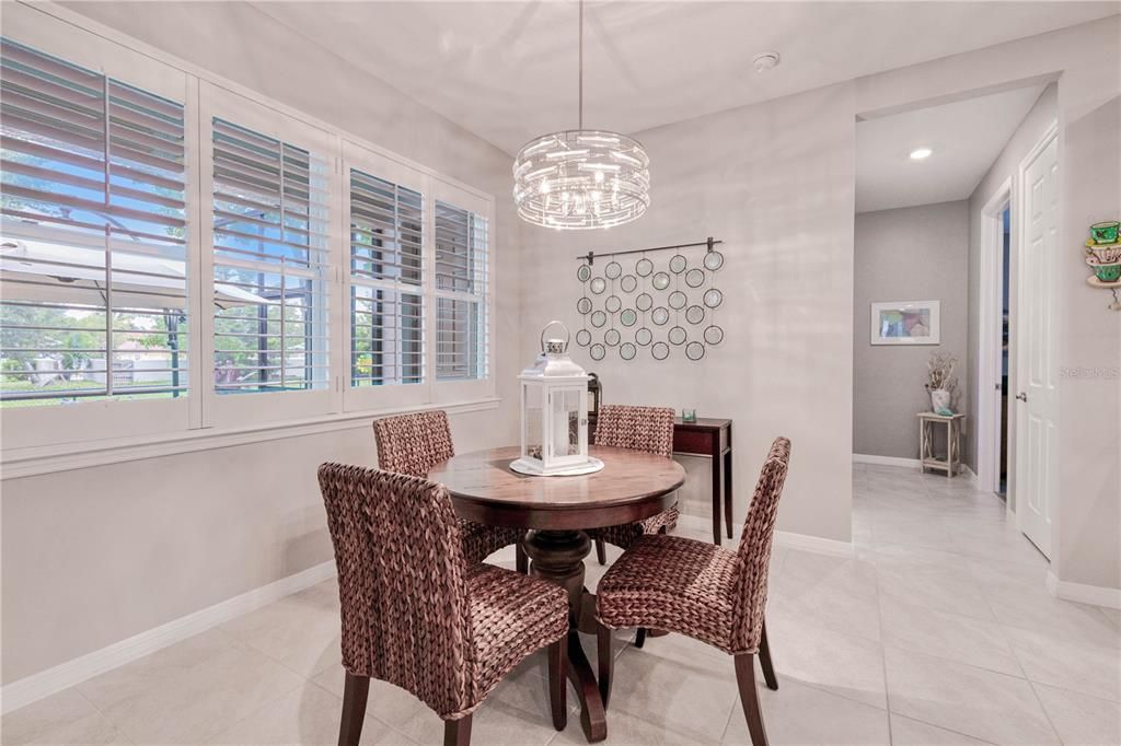 Quaint dining nook overlooking lanai and tropical landscaping