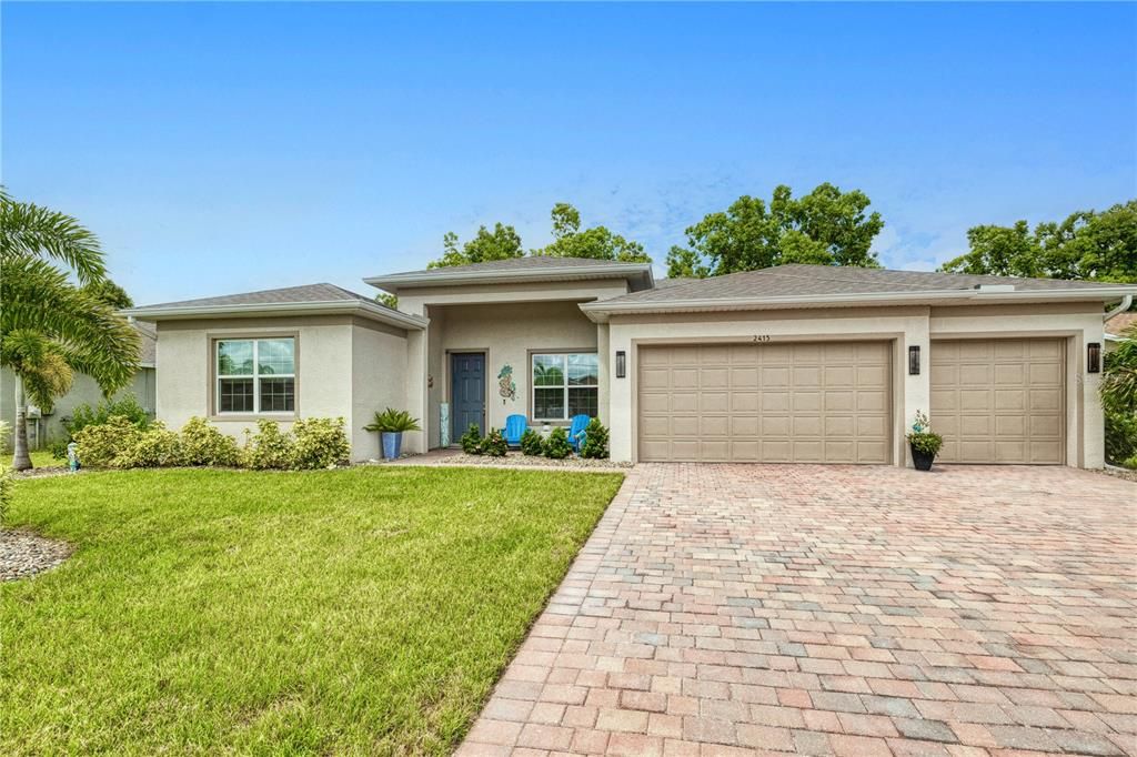 3 car garage with long pavered driveway