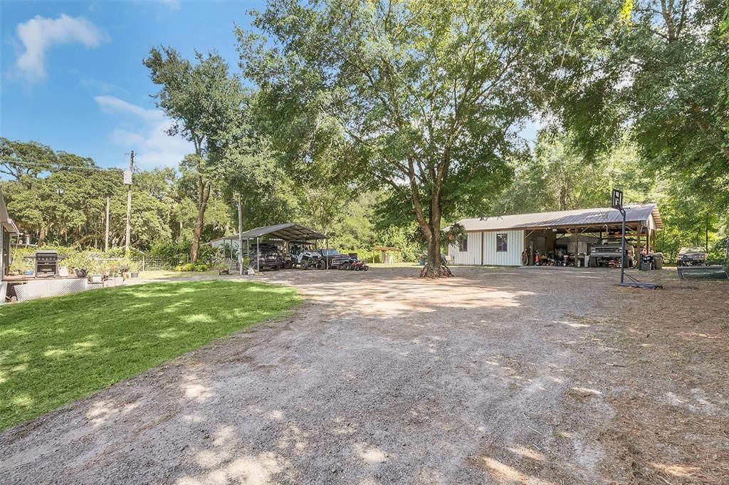 View of the backyard by the carport and garage