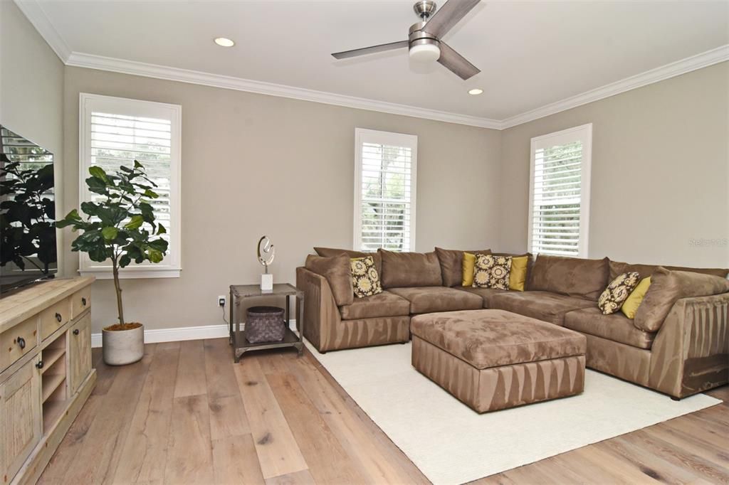 2nd floor bonus room with decorative ceiling fan, recessed lighting, wide-plank wood flooring, crown molding, and large windows with plantation shutters