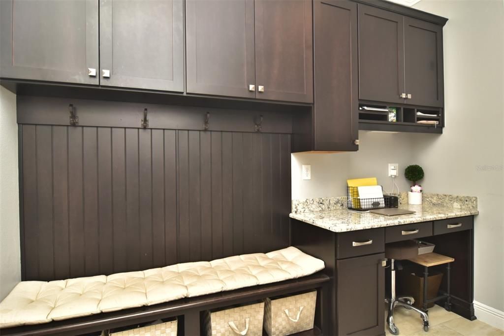 Mudroom, next to kitchen, with cabinetry and desk area