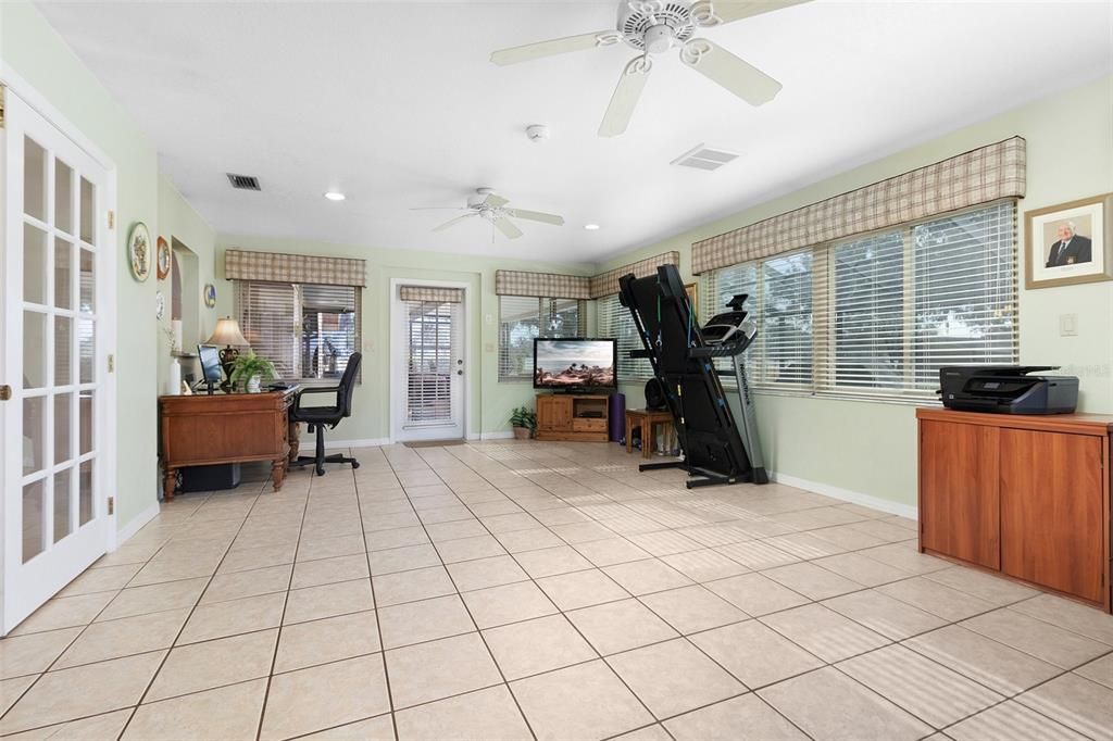 The large sunroom is currently being used as a home office & work out area.