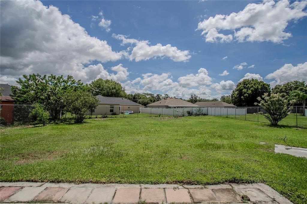 Backyard with mature fruit-bearing banana plants and multiple cherry trees