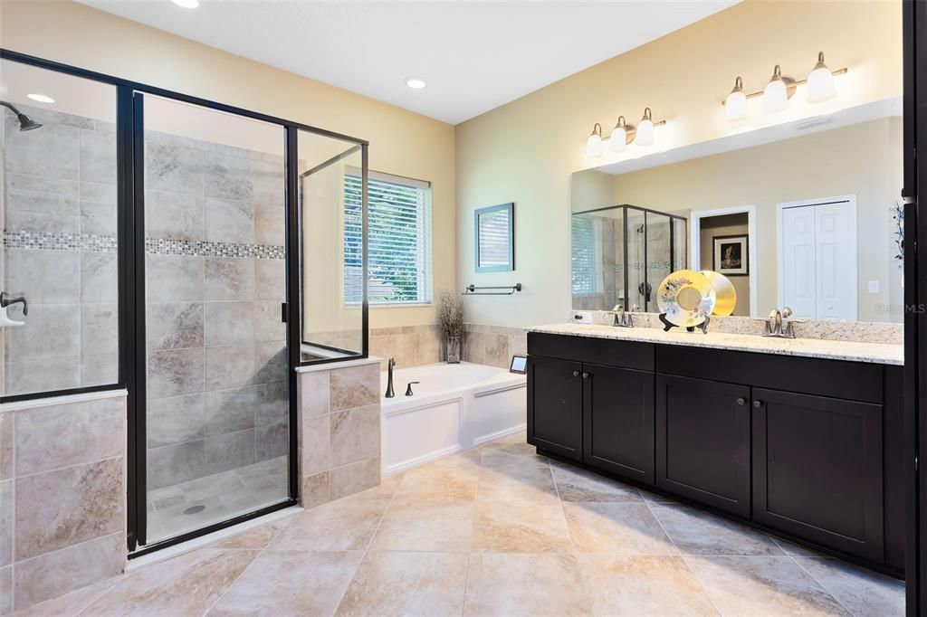 Your luxurious en suite bath includes dual granite-topped vanities, a sumptuous soaking tub and a large shower.