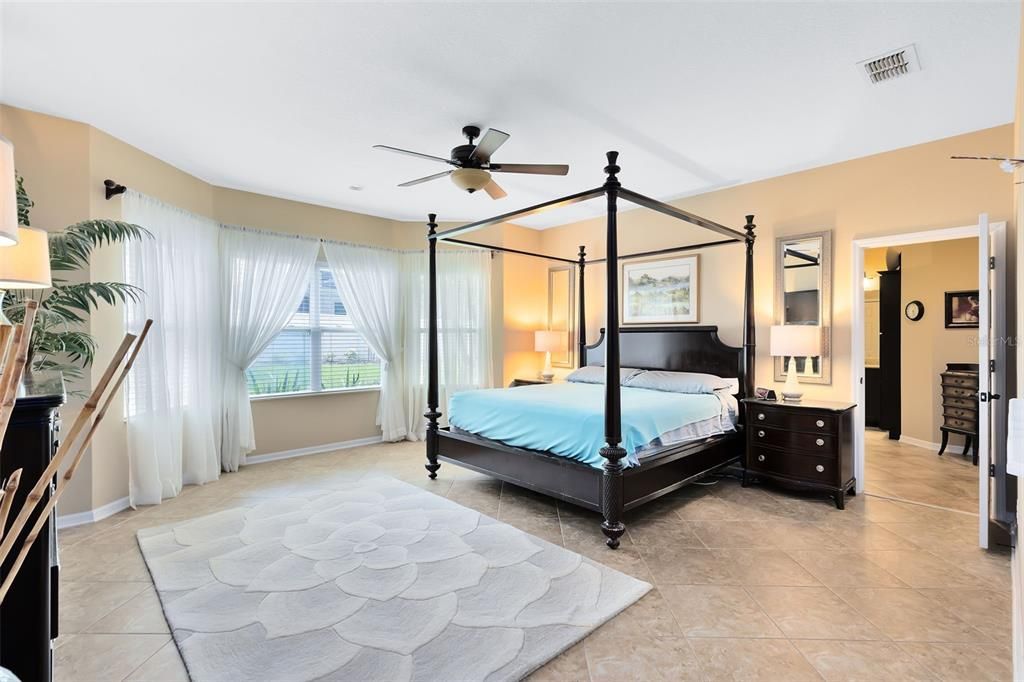 Welcome to your primary bedroom with a beautiful backyard and pool view.