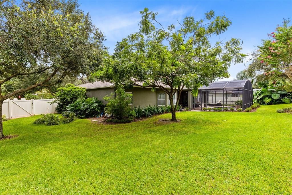 A large, fenced backyard, with its lush landscaping, offers a private retreat.