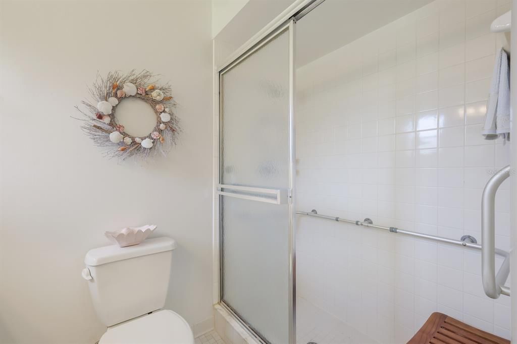 Stand up shower with handicap bars in primary bathroom