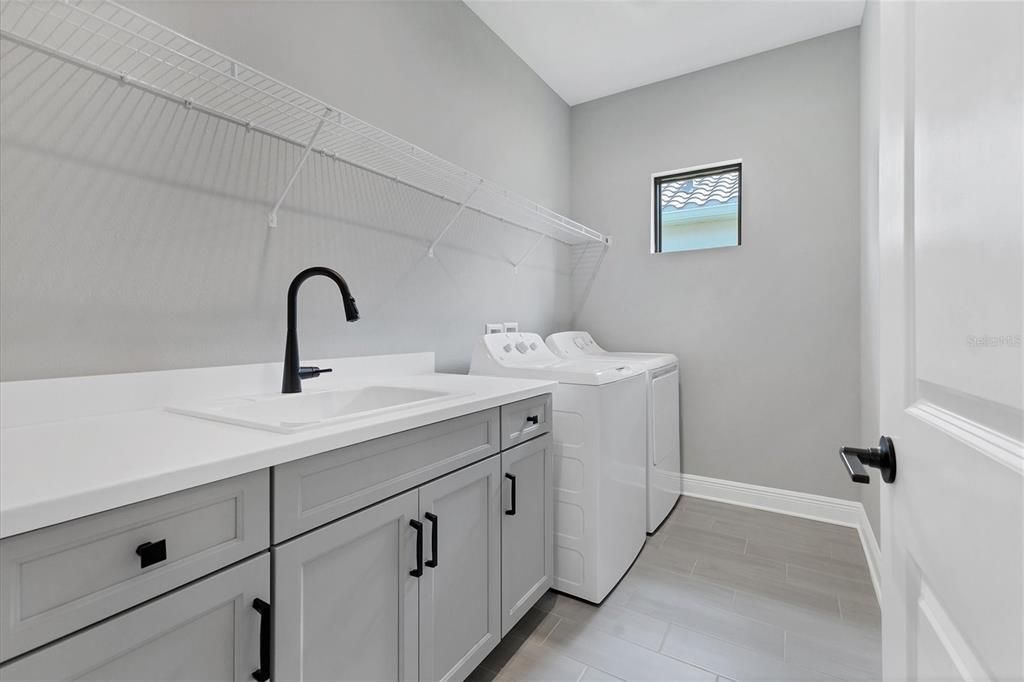 Laundry room features built in sink and storage.