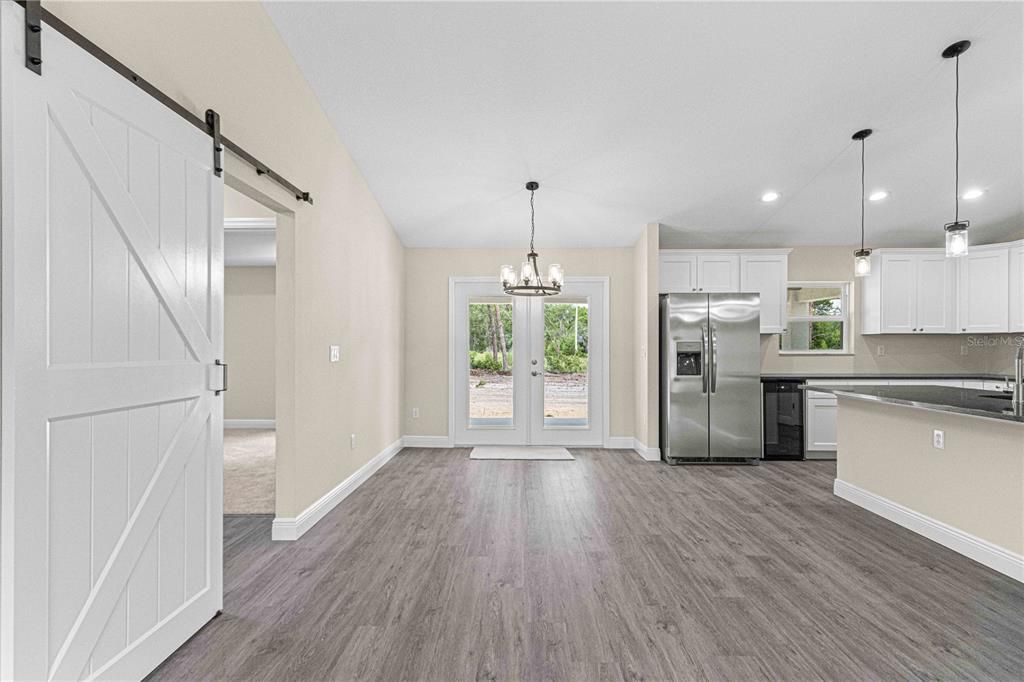 Living space with vaulted ceilings, upgraded light fixtures and ceiling fan