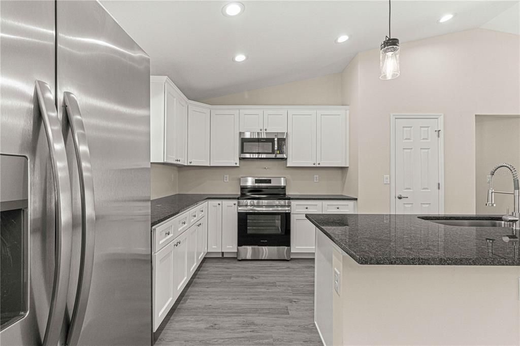 Kitchen area omes with itchen backsplash, pot filler faucet, wine refrigerator and hood