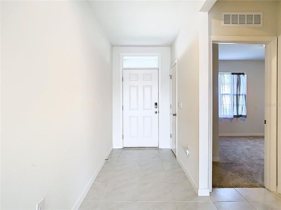 view of front door and entrance to front bedroom.