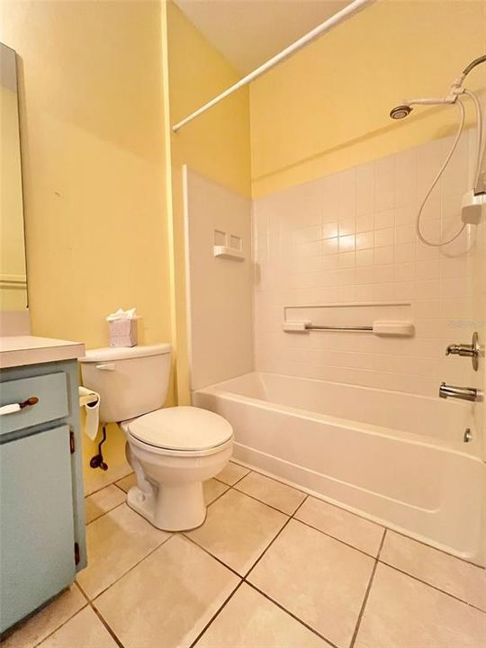 The second full bathroom has an oversized tub with grab bars, tile flooring, a newer toilet, and great cabinet space.