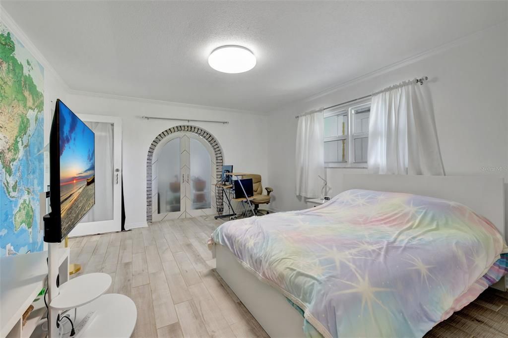 This guest bedroom is next to the living room. The arched doors lead to the pool area.