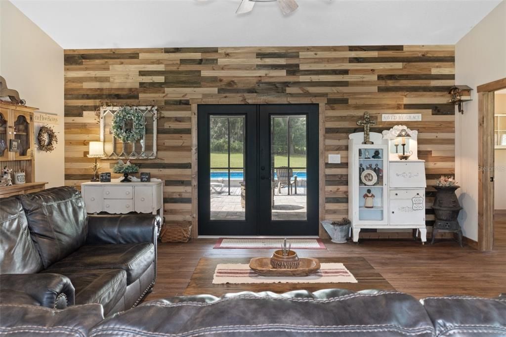 Shiplap accent wall in living room. Doors lead to lanai