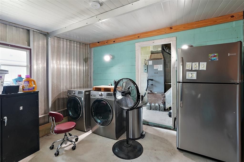 STORAGE ROOM WITH THE WASHER AND DRYER ALONG WITH MORE STORAGE IN THE BACK