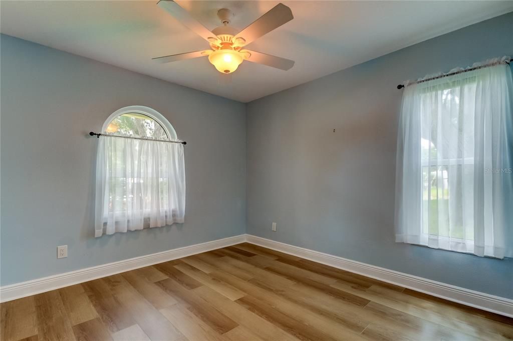 Bedroom #3 Features Arced Window, Large Wall to Wall Closet, Fan, Durable Laminate Floors.. w/Light Sky Blue Paint!