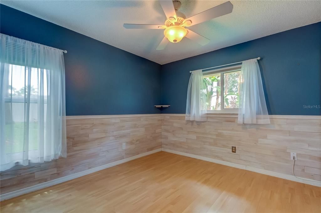 Bedroom #2 Features Wood Planks up to Chair Rail, Large Wall to Wall Closet, Fan, Durable Laminate Floors.. w/Deep Sea Blue Paint!