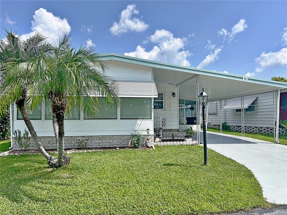 Front exterior w screened in carport, carport, freshly painted outside and driveway