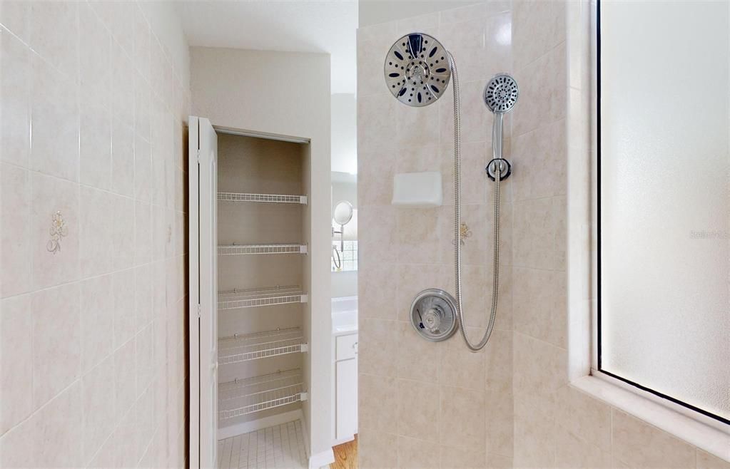 Linen closet at the end of the shower area.