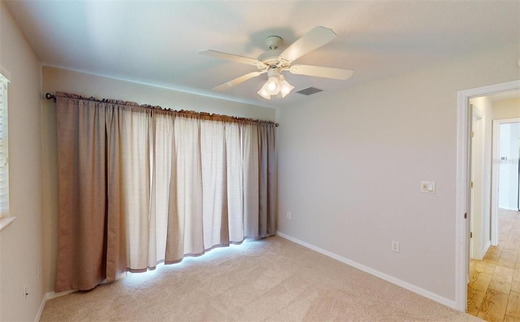 Bedroom #2 with ceiling fan and drapes closed.