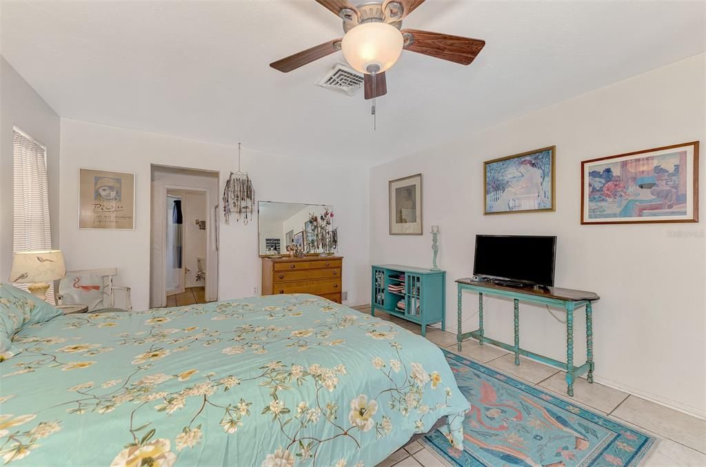 Spacious primary bedroom with a serene ambiance. Enjoy relaxing in this bright and airy room, featuring a ceiling fan and ample natural light.