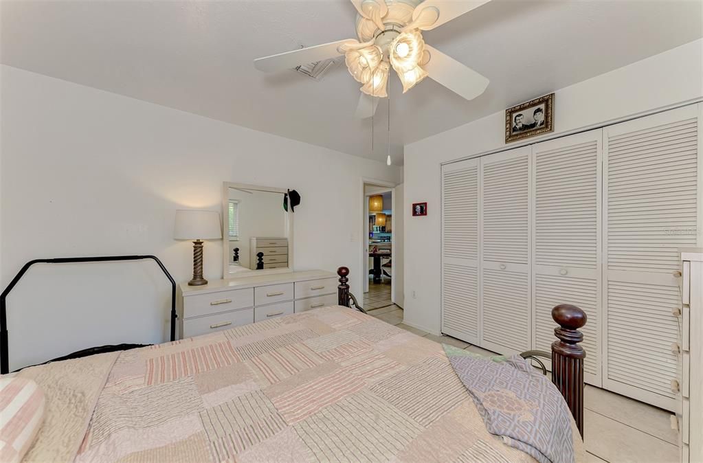 Bright and airy guest bedroom. Enjoy a peaceful night's sleep in this inviting room, featuring ample natural light and a ceiling fan.