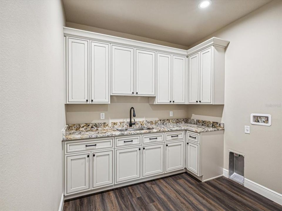 Huge Laundry Room with custom cabinets and a large sink