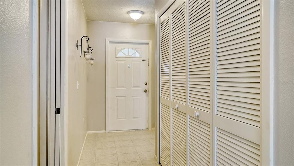 View of hallway leading to front door.  To the right is a large closet for storage and/or pantry.