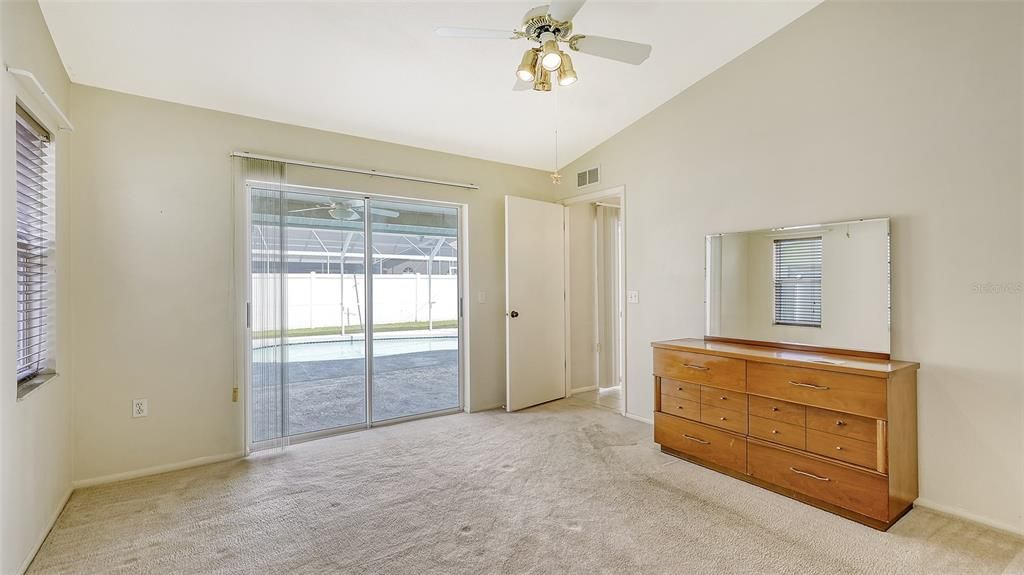 Primary Bedroom leads out to the lanai and pool.