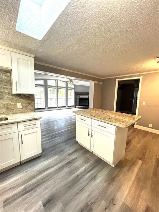 KITCHEN AND FAMILY ROOM VIEW FROM FORMAL LIVING ROOM