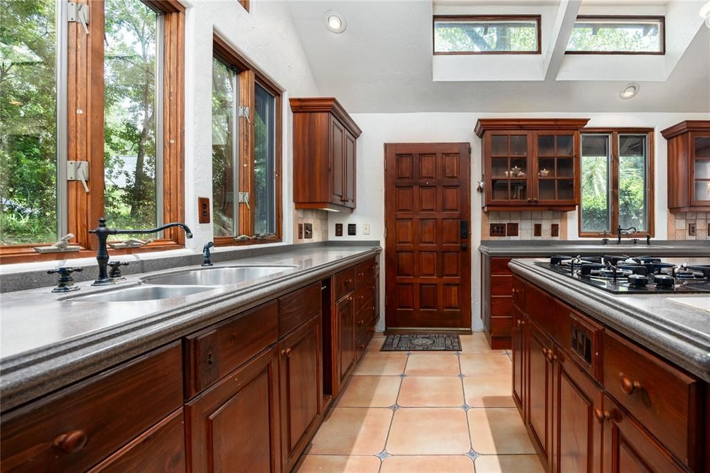 Two sinks, natural gas range, corian counter tops and wood cabinetry