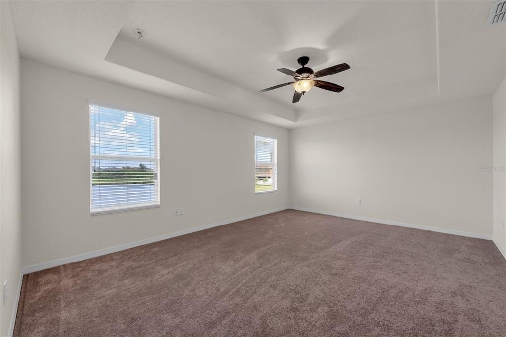 Primary Bedroom with tray ceiling and ensuite bathroom with l10' x 5' walk-in closet.