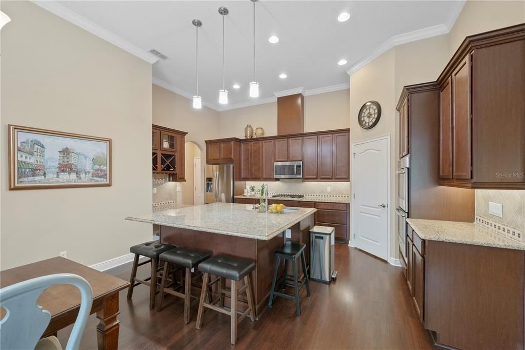 Kitchen includes a large prep island with an abundance of seating