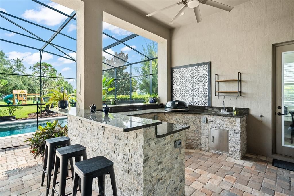 Custom kitchen with grill and mini refrigerator.