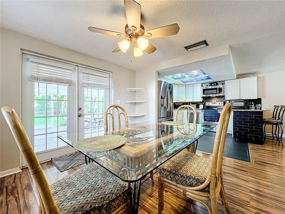 Dining room also has wood laminate flooring and French doors lead to the expansive lanai.