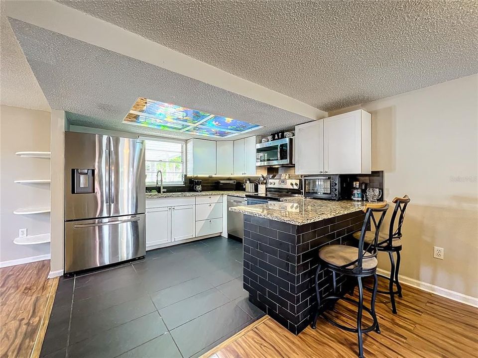 Kitchen offers stainless steel appliances, granite counters, and white cabinets.