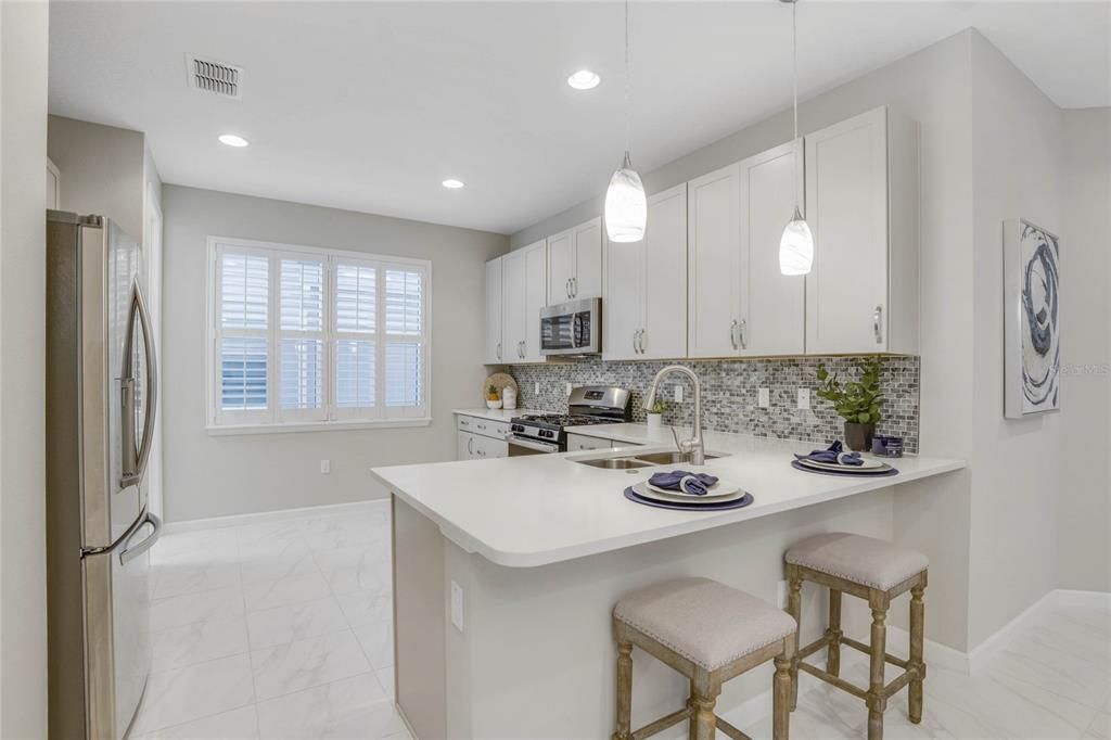 14' x 10' Kitchen area w/ pendant lights above breakfast bar