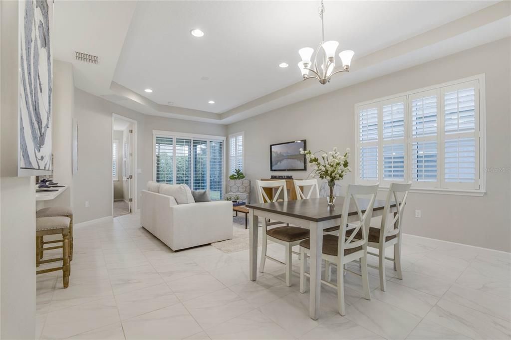 View of Dining & Great Room areas w/ ceramic tile floor, tray ceiling & recessed lighting