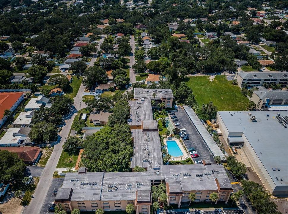 An aerial shot capturing the condo complex from above, showcasing the layout, surrounding green spaces, and the overall setting.