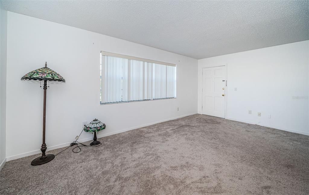 A clean and empty living room with a generous layout, allowing you to envision and build your dream living area.