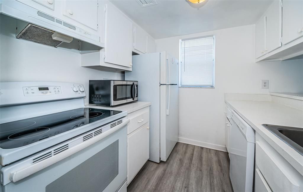 A warm and inviting kitchen with a simple design, featuring essential amenities and a cozy atmosphere perfect for everyday cooking.