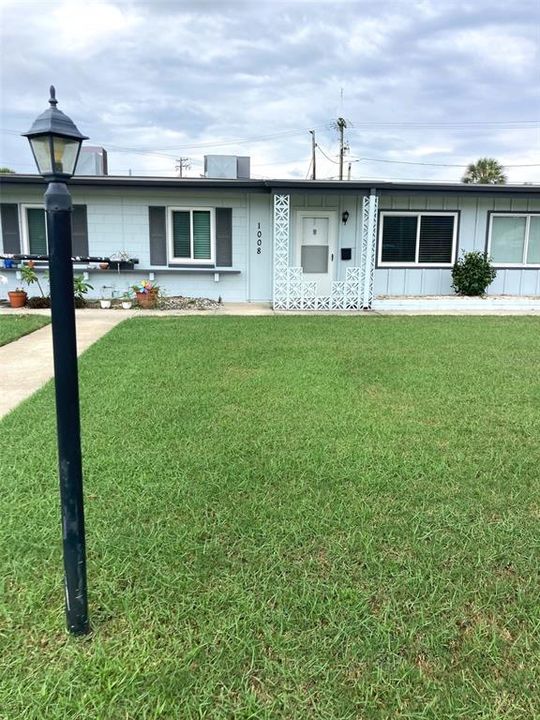 Front door faces a spacious grass area.