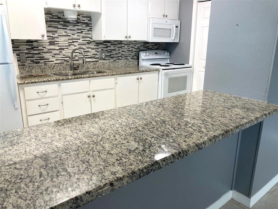 Stone countertop serving bar makes a great eating space.