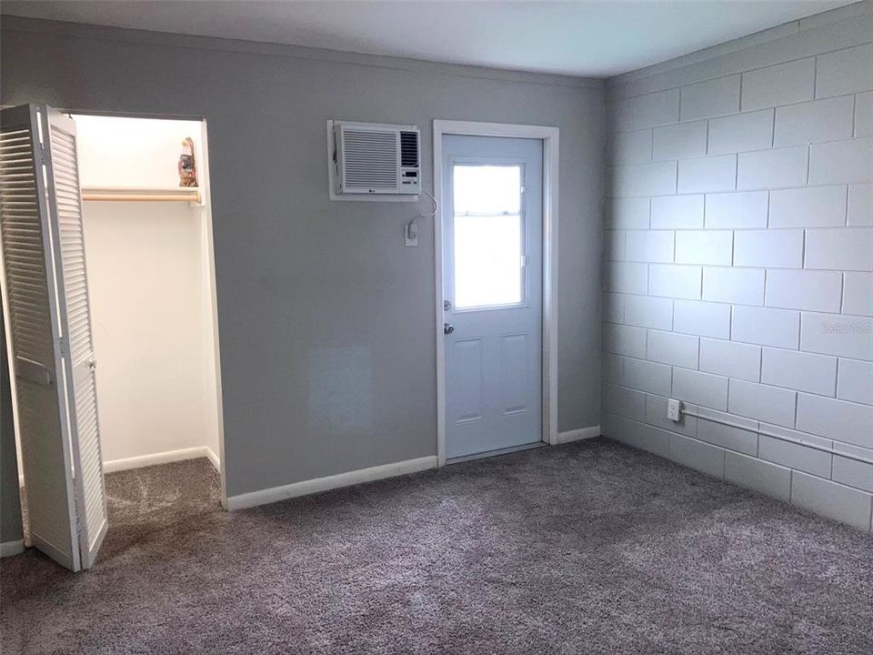 Study/office space includes closet, AC unit for climate support, and doorway to patio.