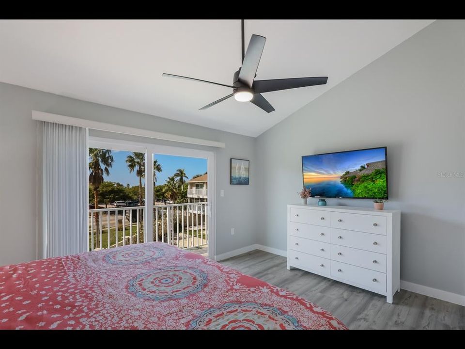 Lots of light in primary bedroom with vaulted ceilings