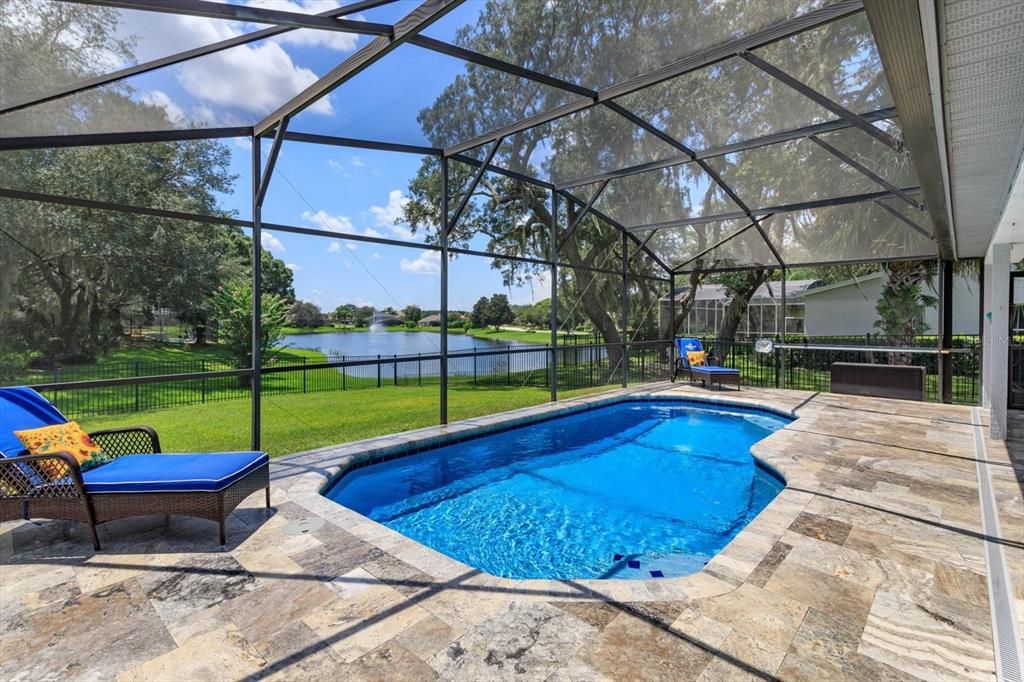 Travertine pavers surround the solar heated screen enclosed pool