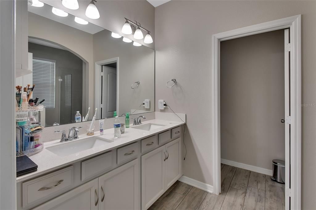 En suite Bathroom with double vanity and water closet.