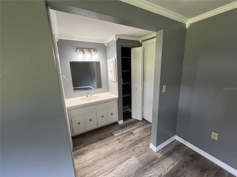 Linin closet and sink in the primary bedroom