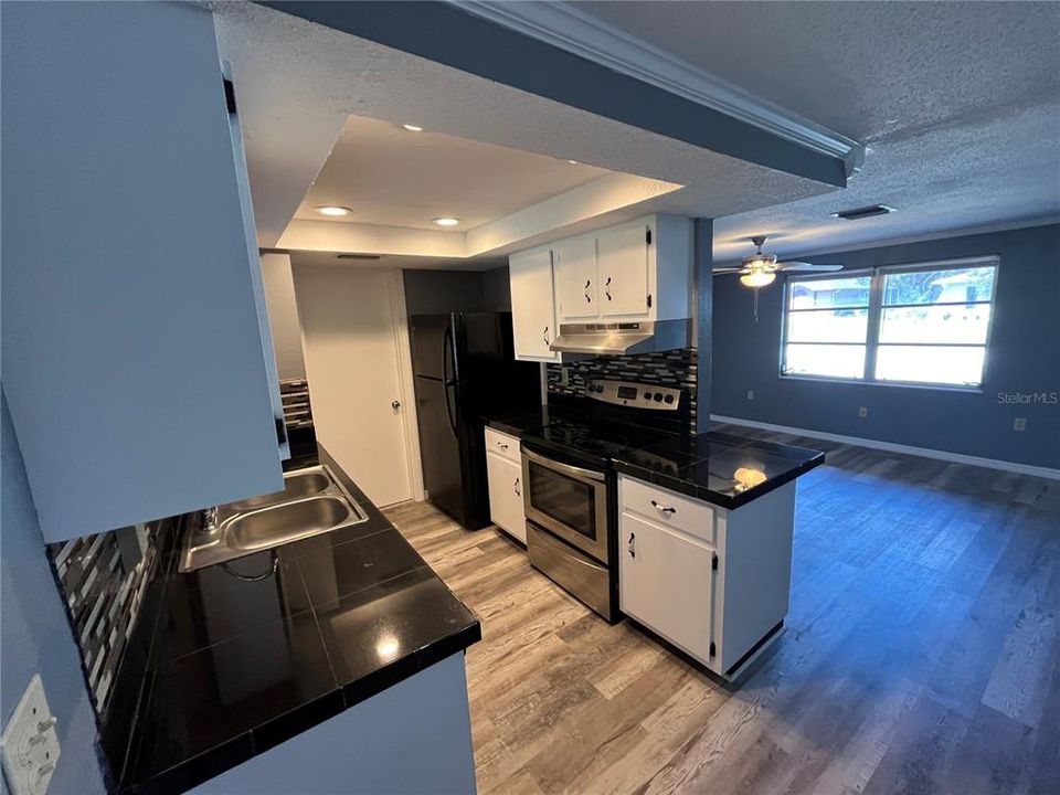 Kitchen overlooking the sun room and living room with a dinning nook