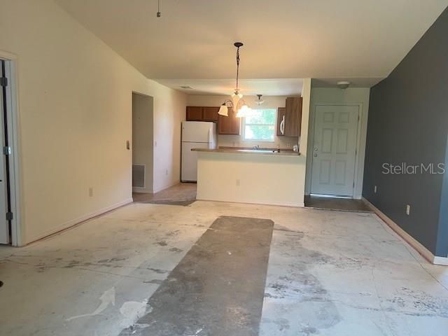 View from Living Room to Dining and Kitchen beyond. View from Living Rood to Dining Room - exposed concrete flooring.